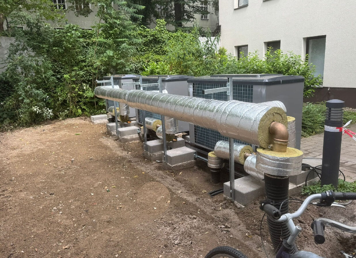 Vorbereitung Aufstellfl&auml;che W&auml;rmepumpe mit ged&auml;mmter Leitungsf&uuml;hrung, Fundamenten und montierten Au&szlig;eneinheiten