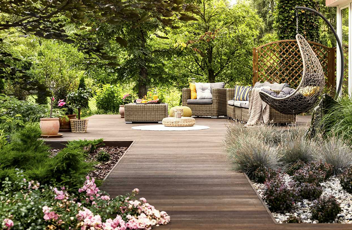 Holzterrasse mit Loungemöbeln und Hängesessel