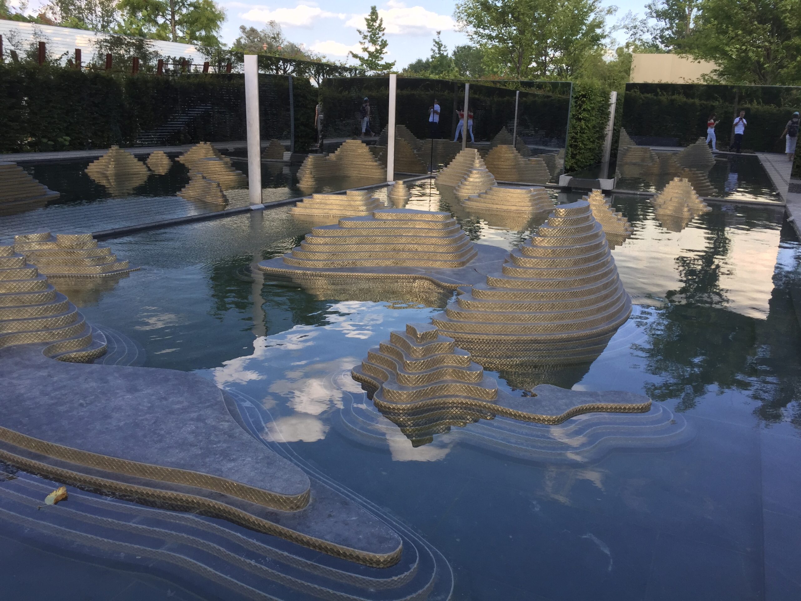 Wasserbecken mit terrassierten Steinelementen in einer Gartenanlage