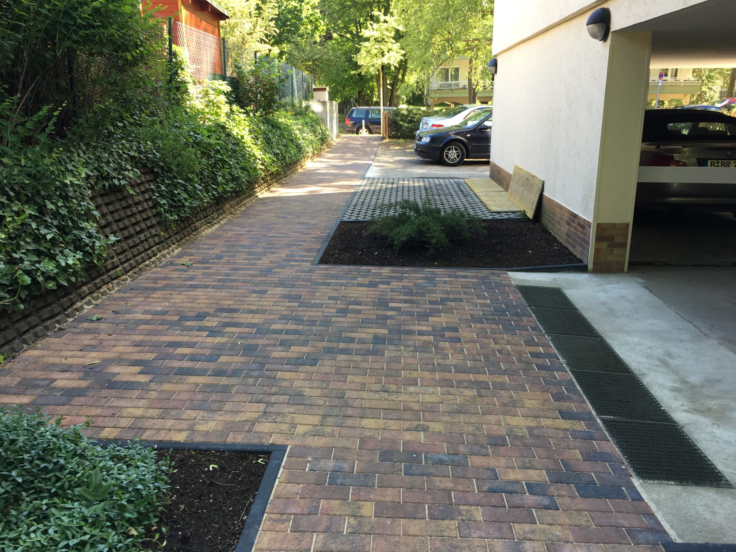 Gepflasterte Zufahrt mit Rasenfugen zur Garage
